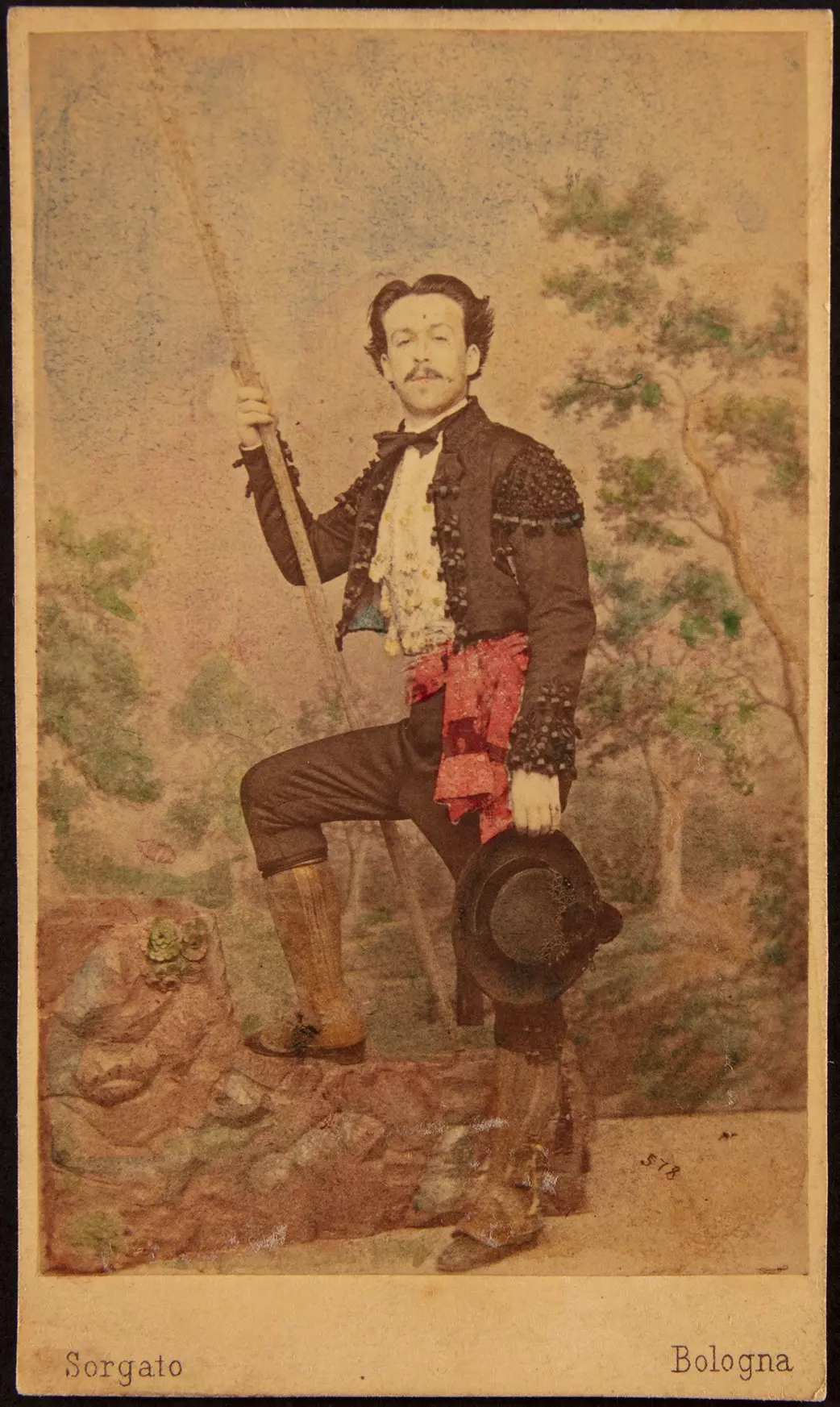 Historisches, koloriertes Porträt eines Mannes in Uniform mit Säbel und Federhut vor Landschaftshintergrund.