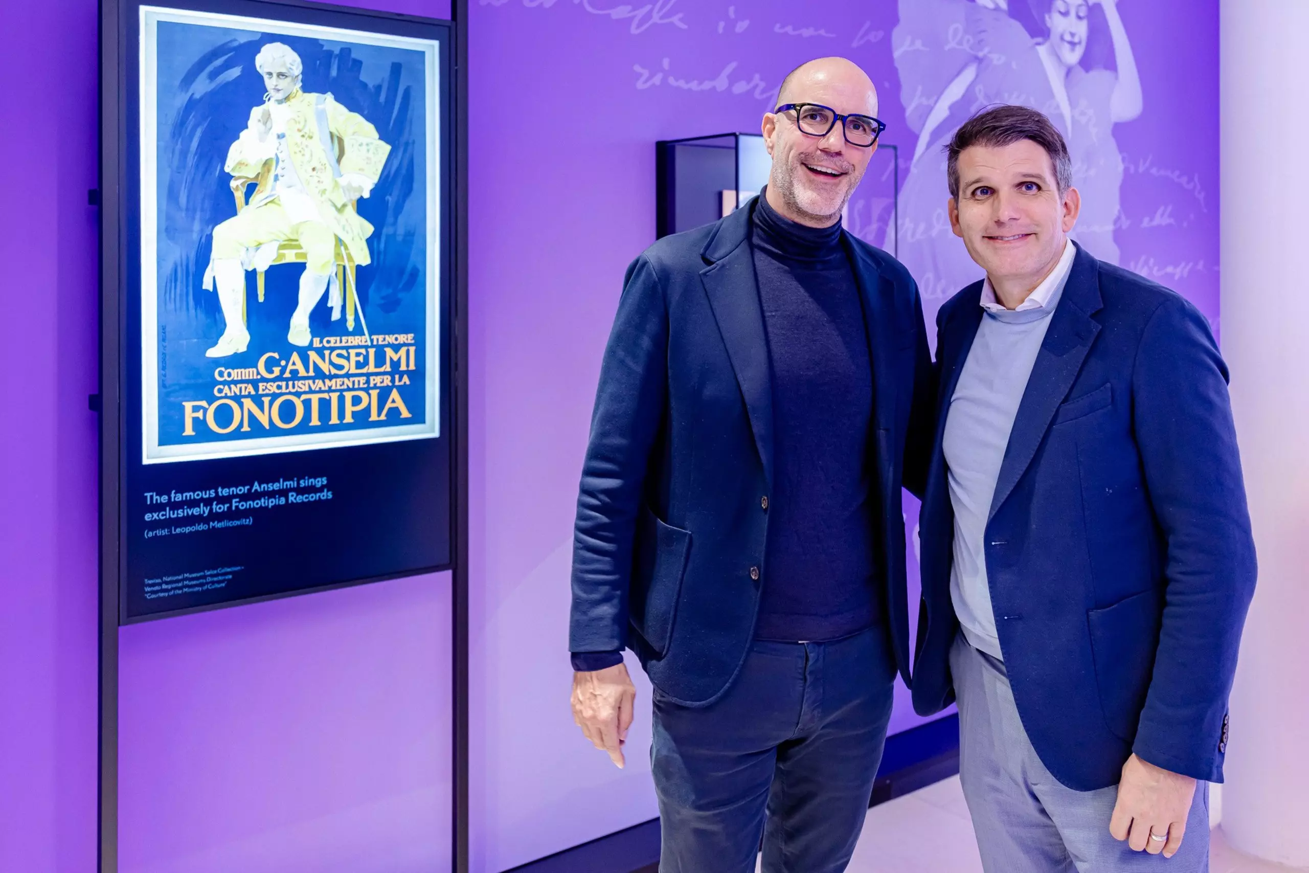 Thomas Götz and Dirk Kemmerer stand in front of an exhibit at the Puccini exhibition