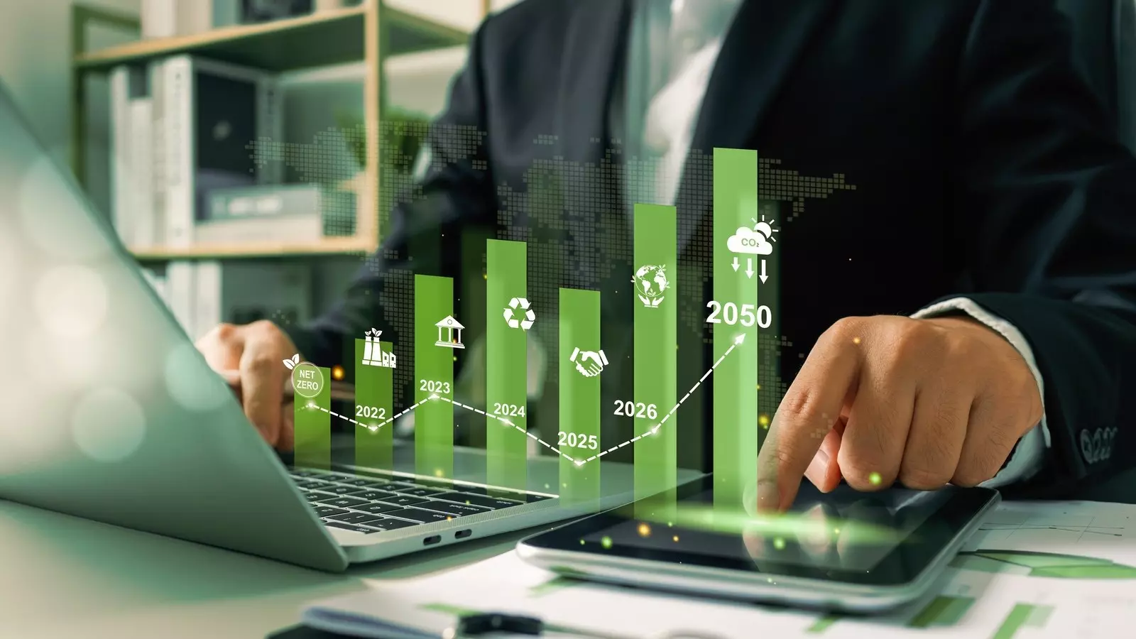 Hand on laptop, bar chart floating above it as a hologram; visualizes ESG metrics, ratings, and performance.