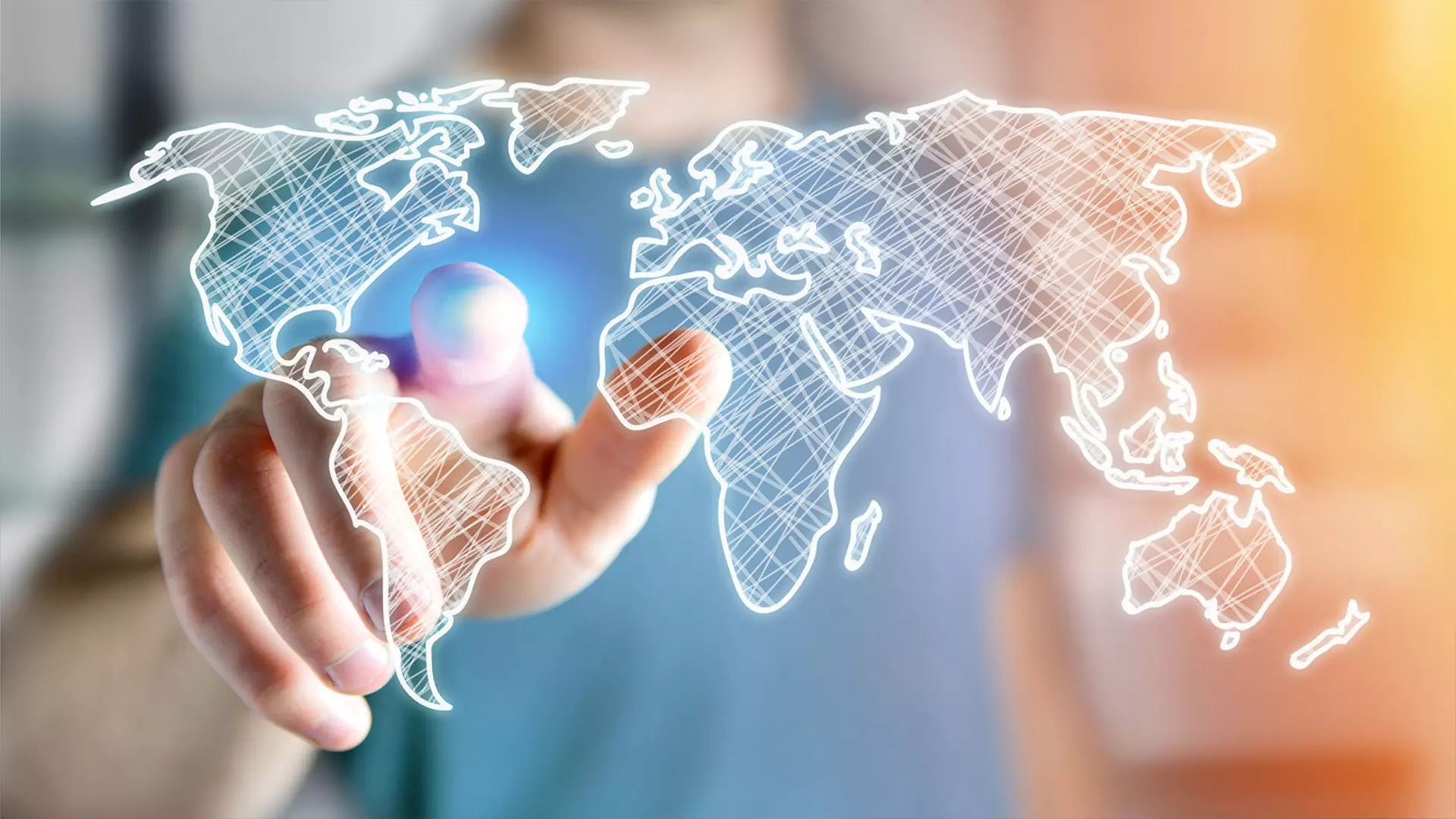 A hand pointing at a map of the world