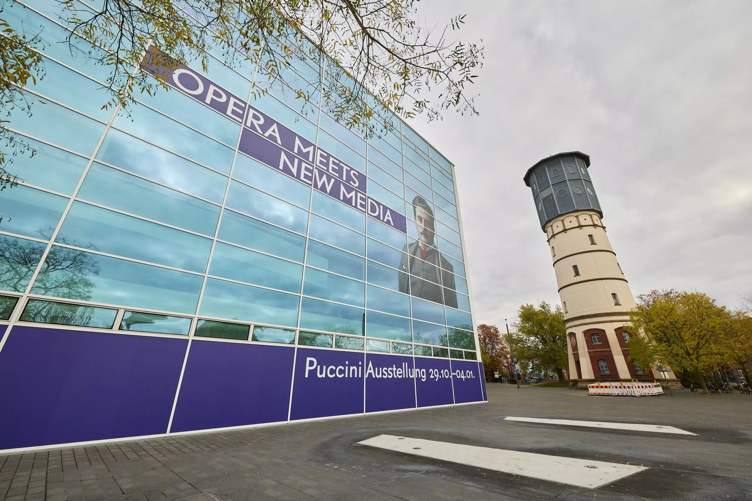 Large-scale facade wrapping of the theater with the lettering “Opera Meets New Media” as an advertising measure for the Puccini exhibition