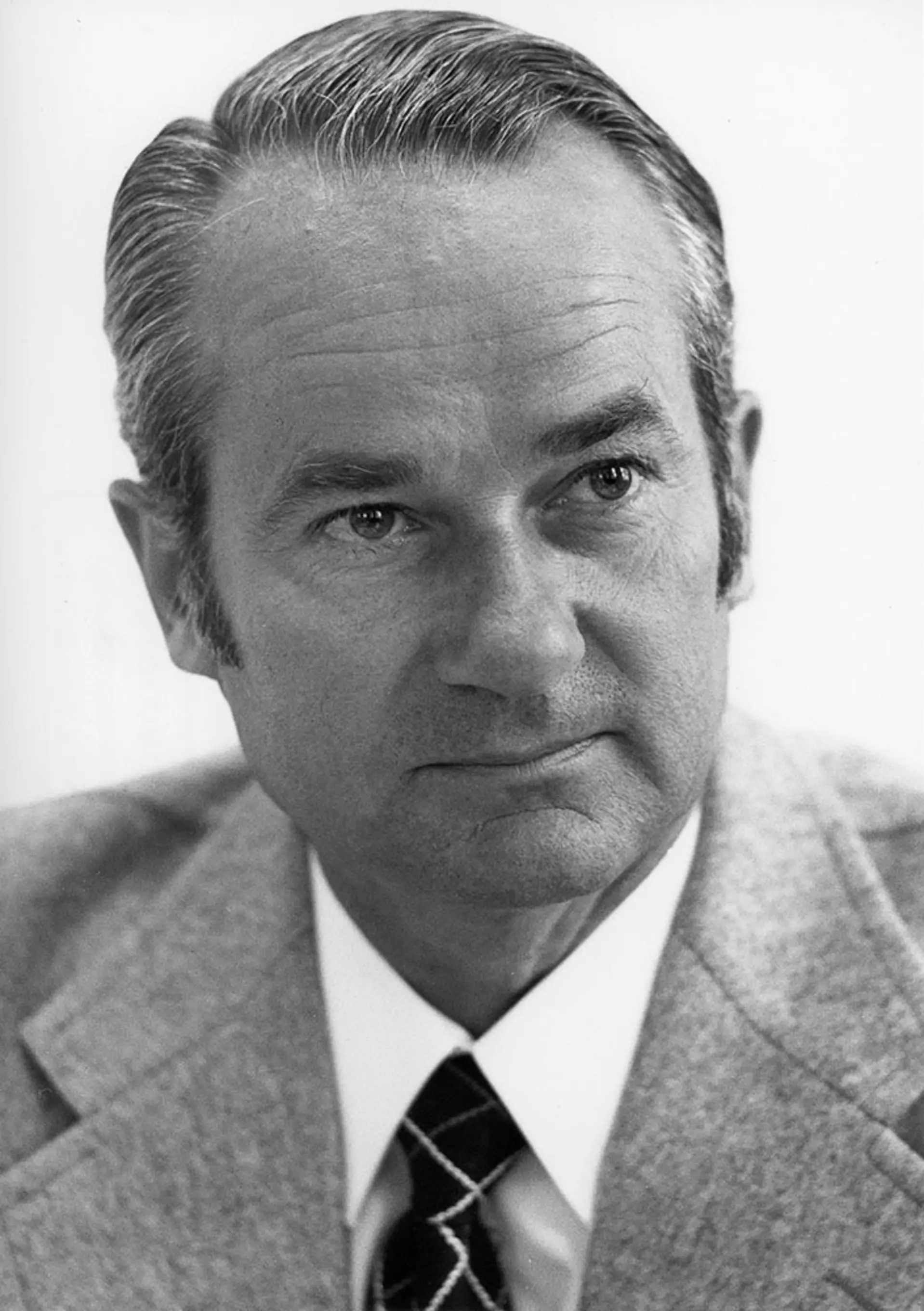 Black and white portrait of Reinhard Mohn in a suit and tie.