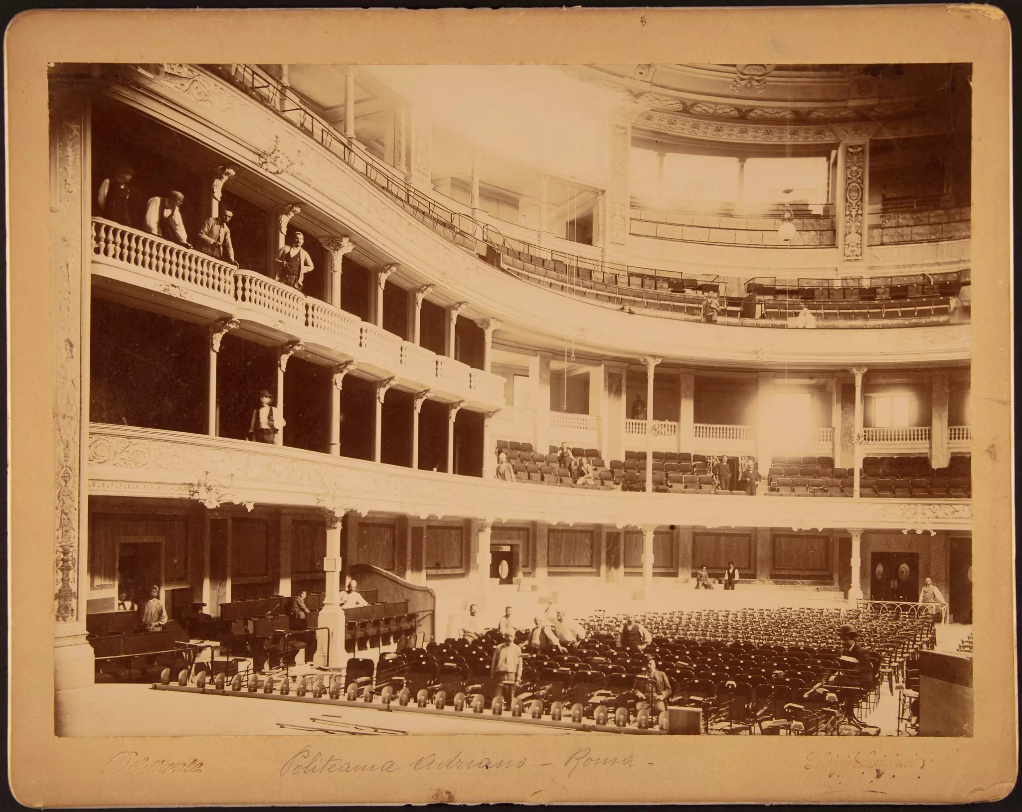 Historische Aufnahme eines Theaterinnenraums mit Rängen, Bühne und Orchester im Parkett.