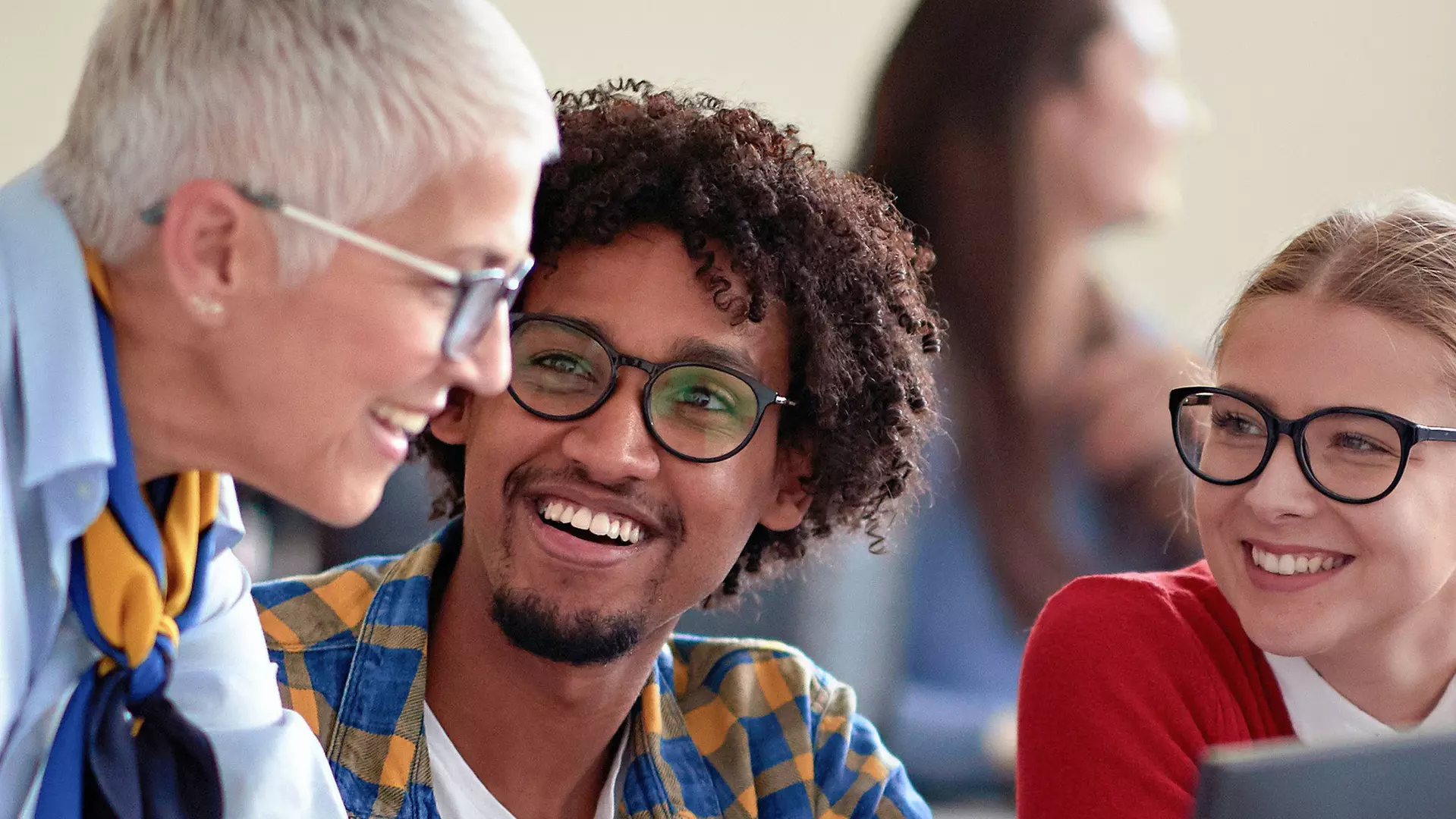 Three people are talking, smiling as they do so.