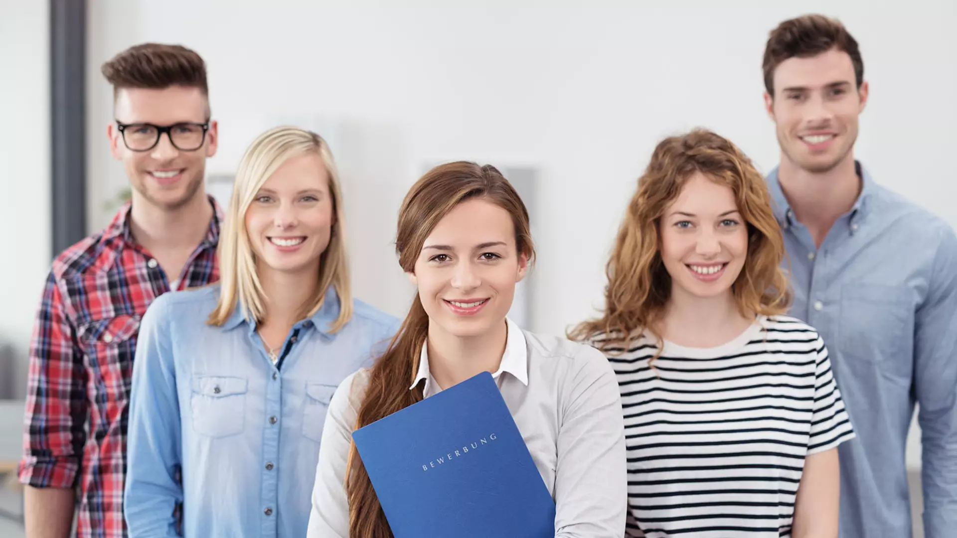 Five graduates smile for the camera.