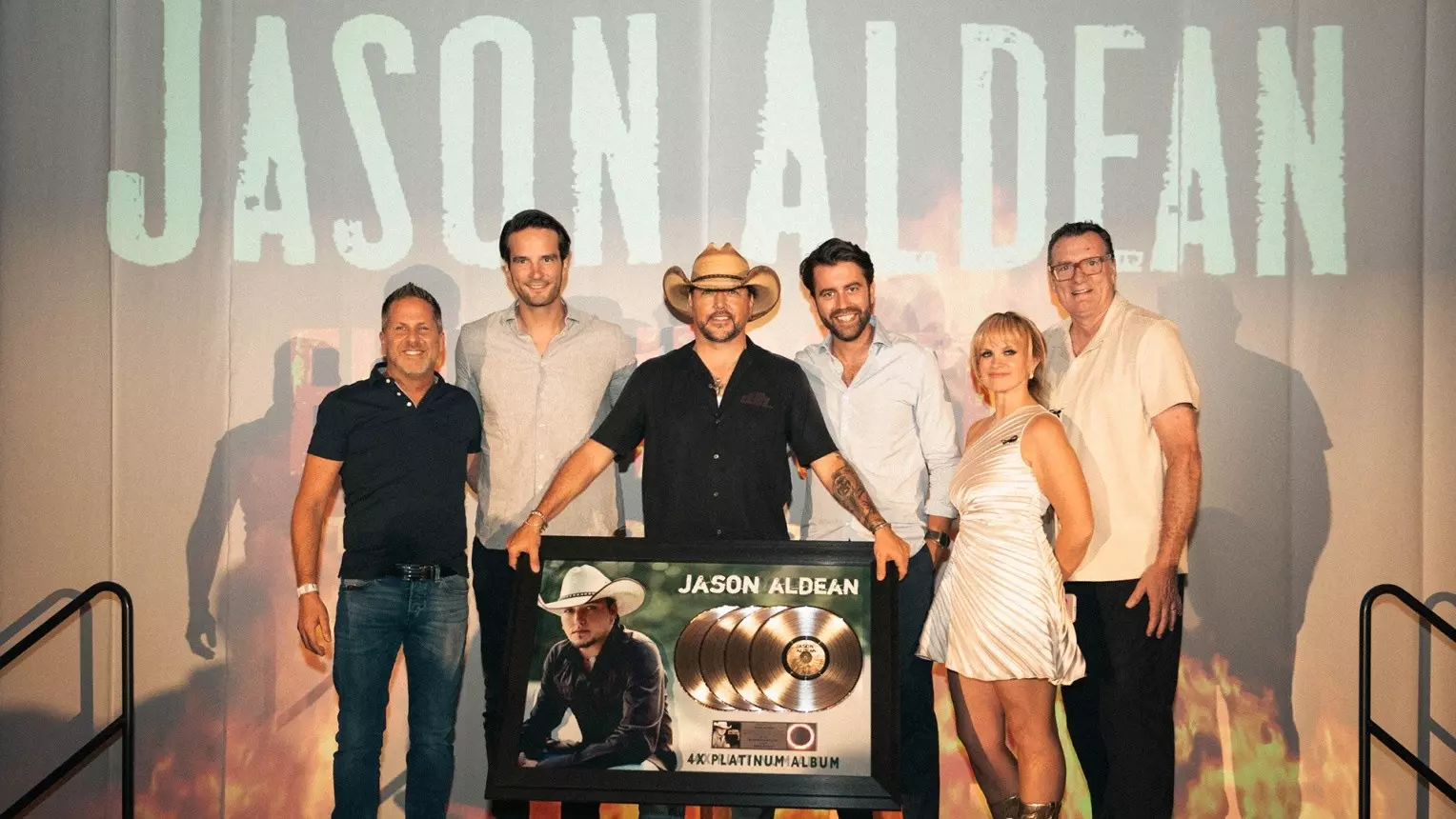 Jason Aldean and BMG management on a stage