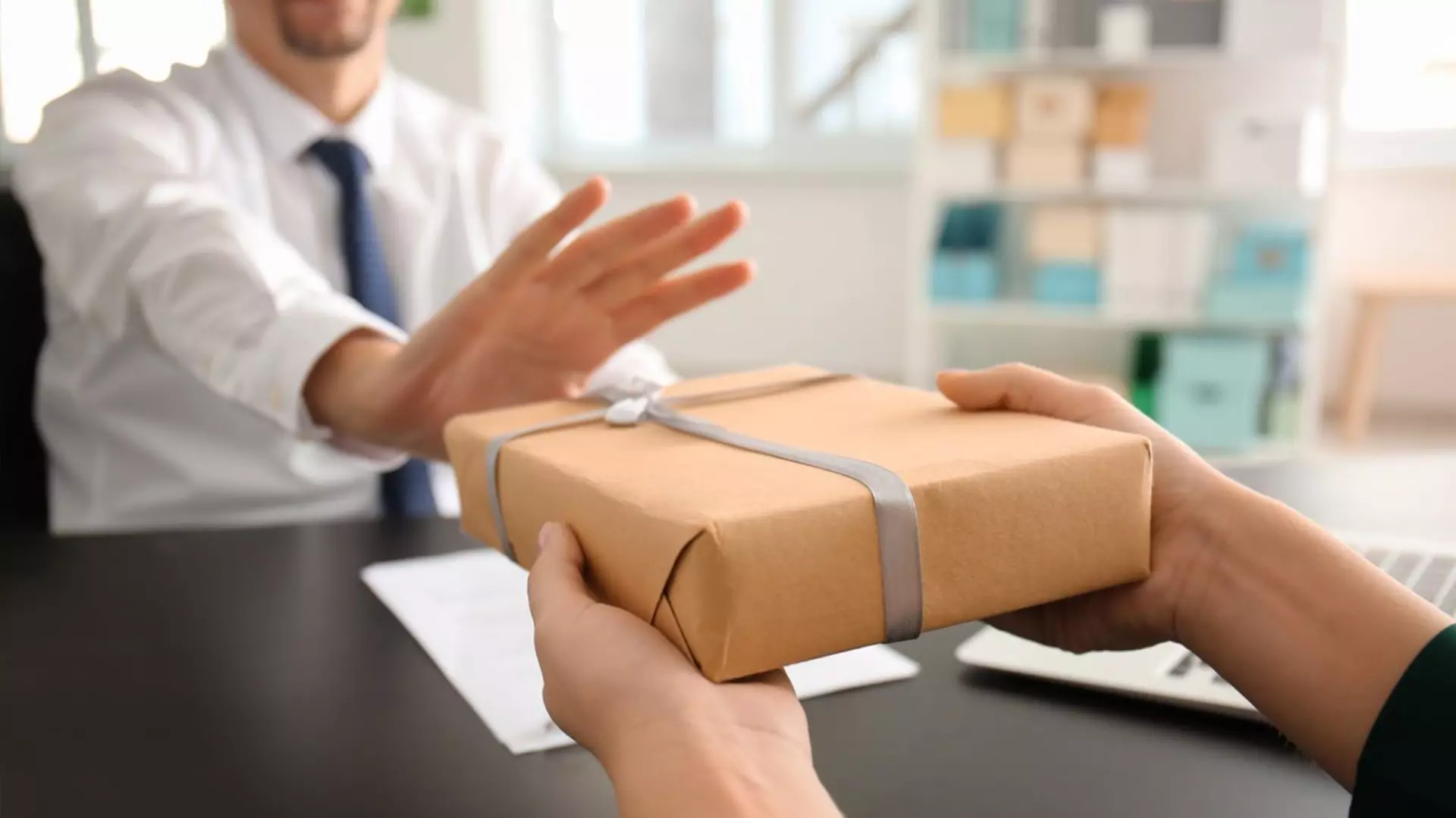 A man who is fending off a gift with his hand