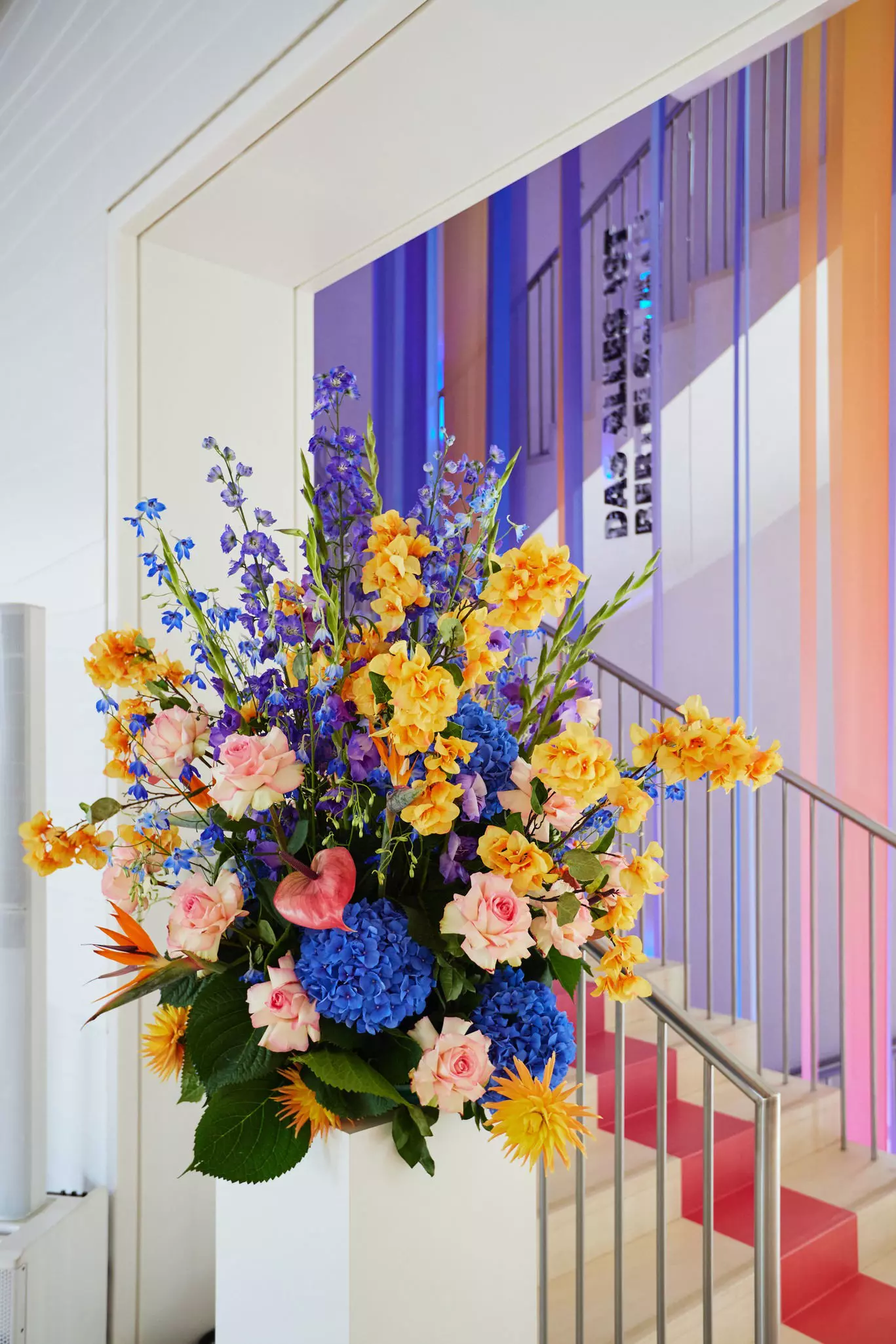 Buntes Blumenbouquet im Foyer der Bertelsmann Repräsentanz vor einem Treppenaufgang.