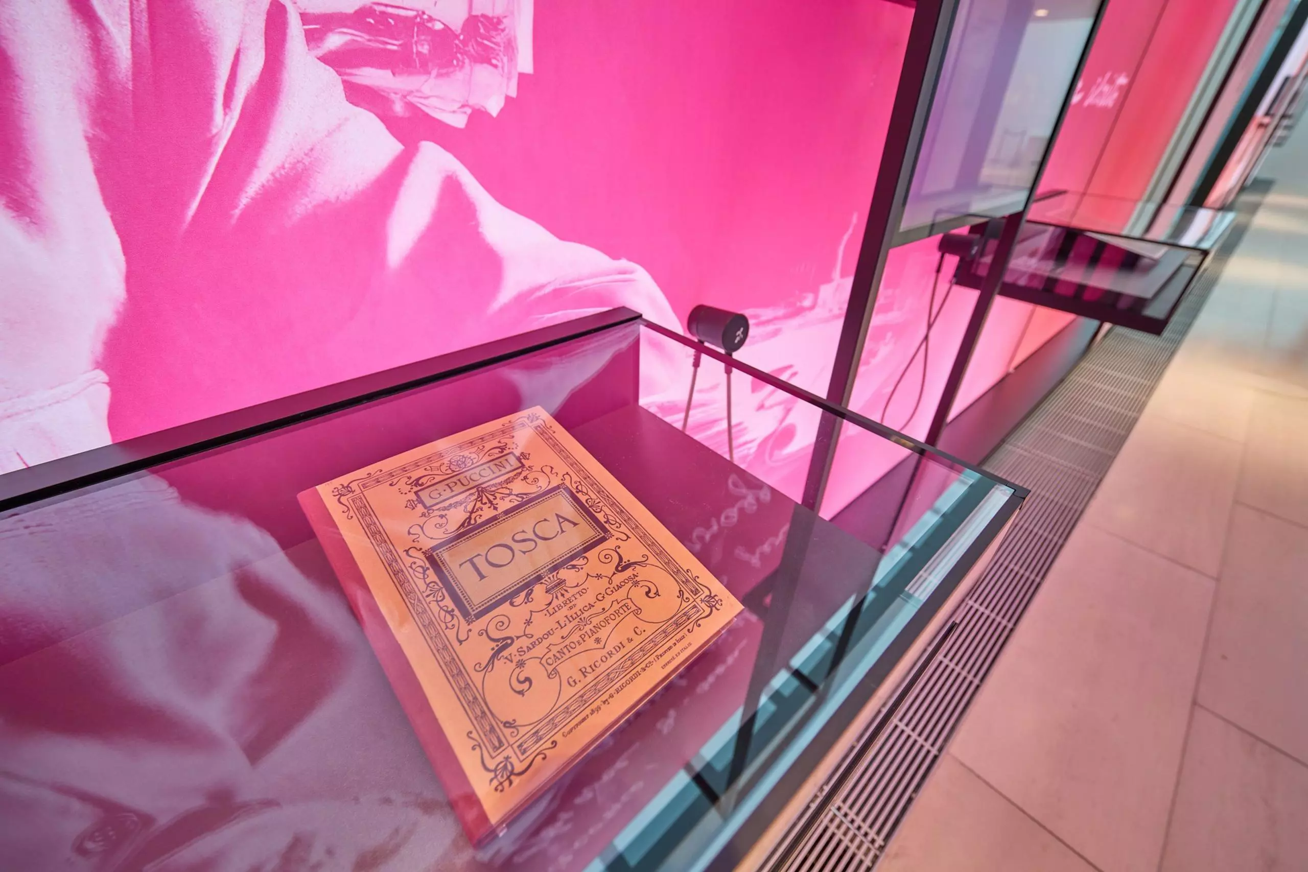 Close-up photo of a book in a glass display case titled “Tosca”
