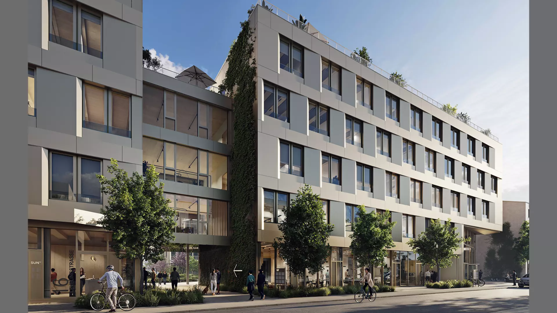 Modern multi‑storey office and commercial building with large windows, a greened facade, and people walking or standing near the entrances.