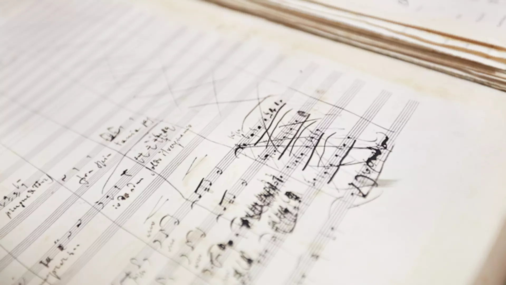 Sheet music page with handwritten musical sketches, corrections, and staff lines on light-colored paper.