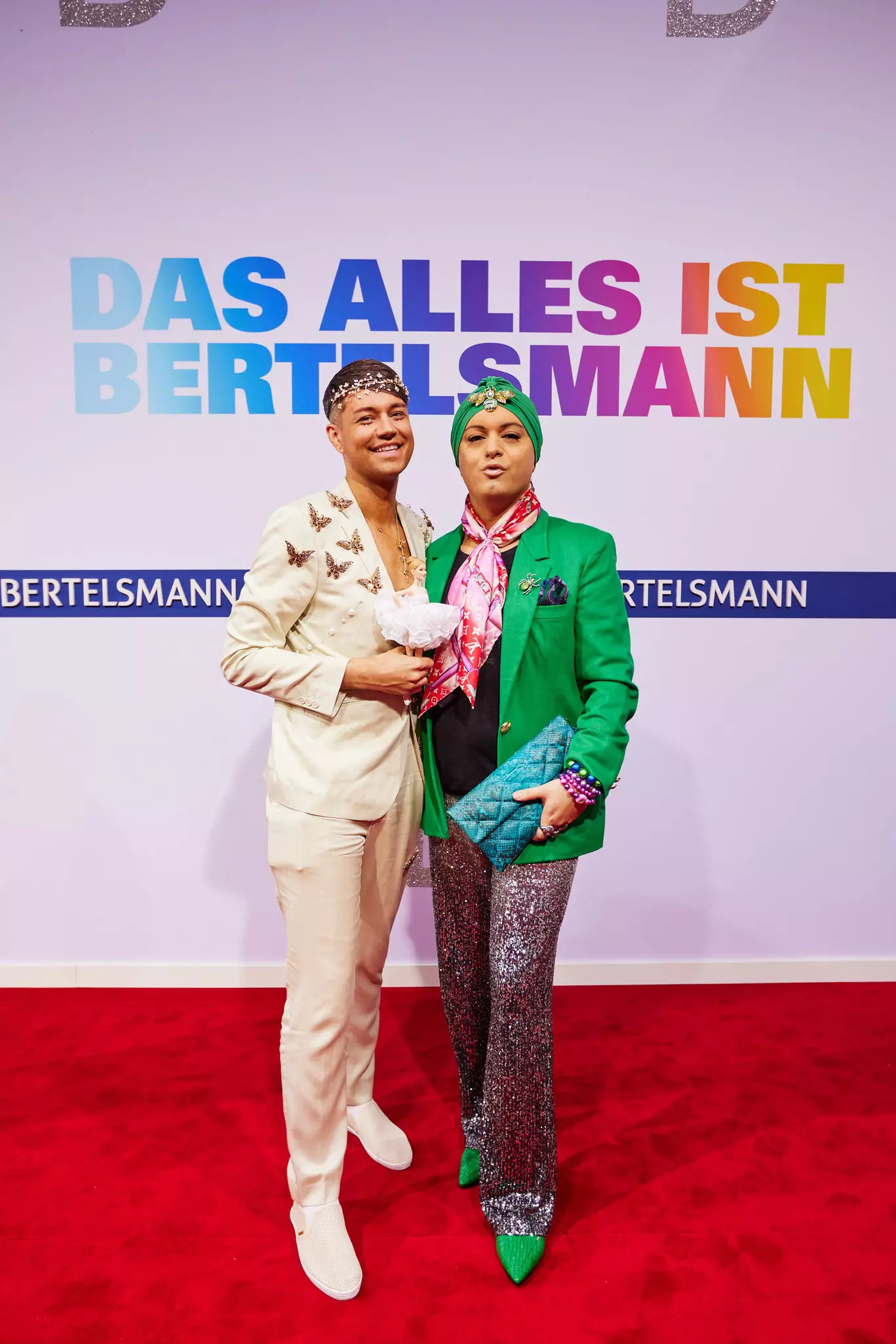 Marcell Damaschke und Julian F. M. Stoeckel vor Bertelsmann-Wand mit Slogan „DAS ALLES IST BERTELSMANN“