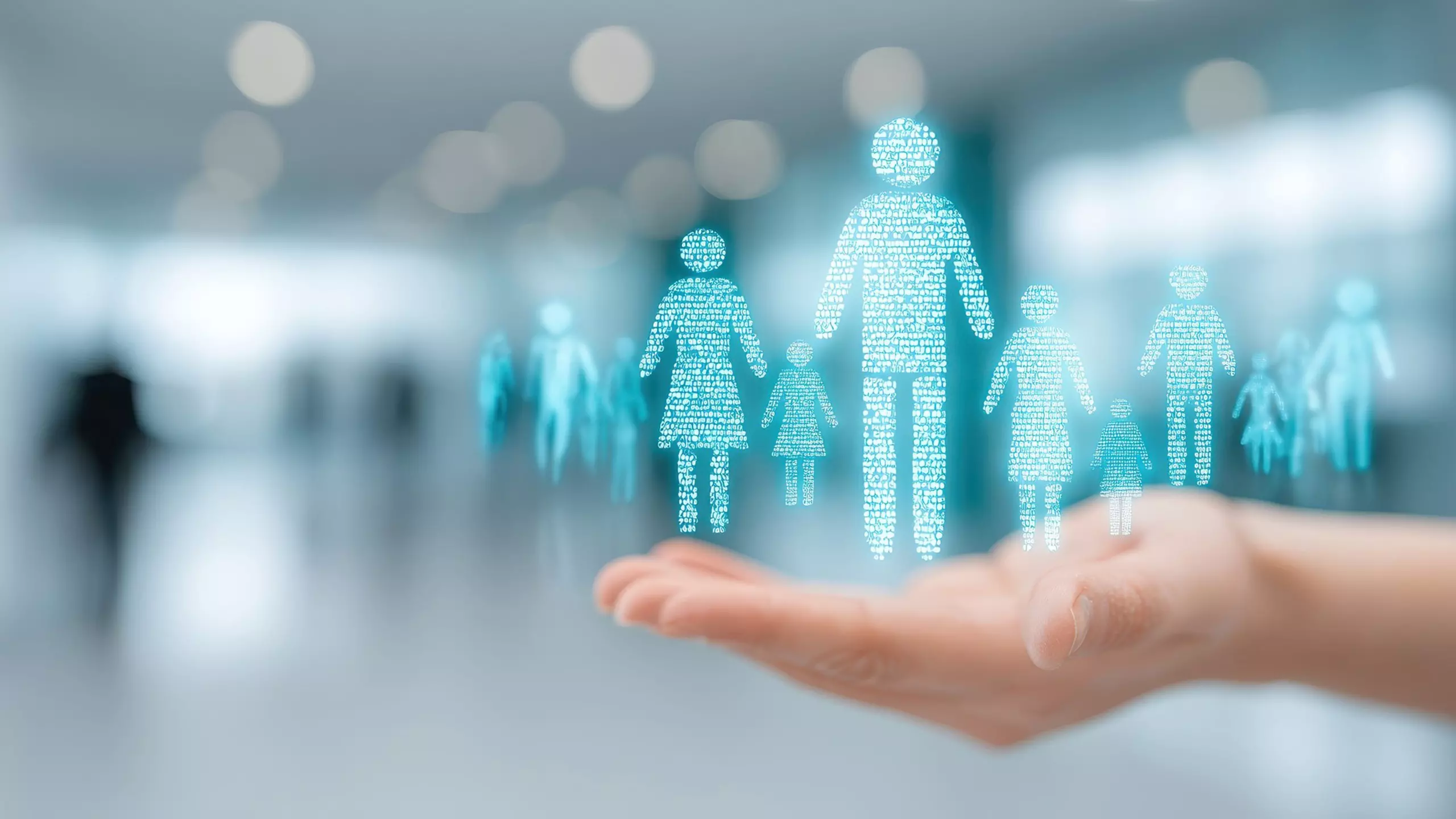 Digitale hellblaue Figuren schweben über einer geöffneten Hand und symbolisieren Schutz und Sicherheit von Menschen.