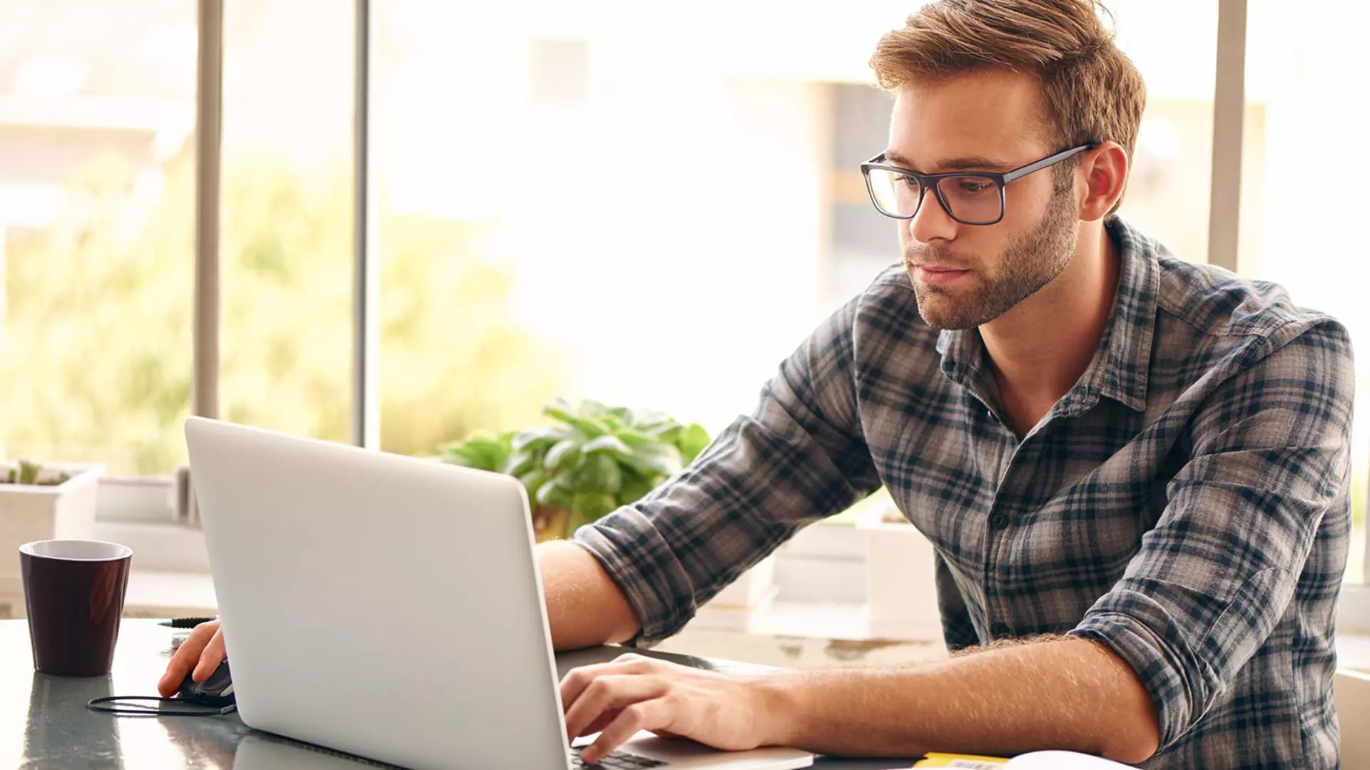 Man wearing glasses sitting at a laptop