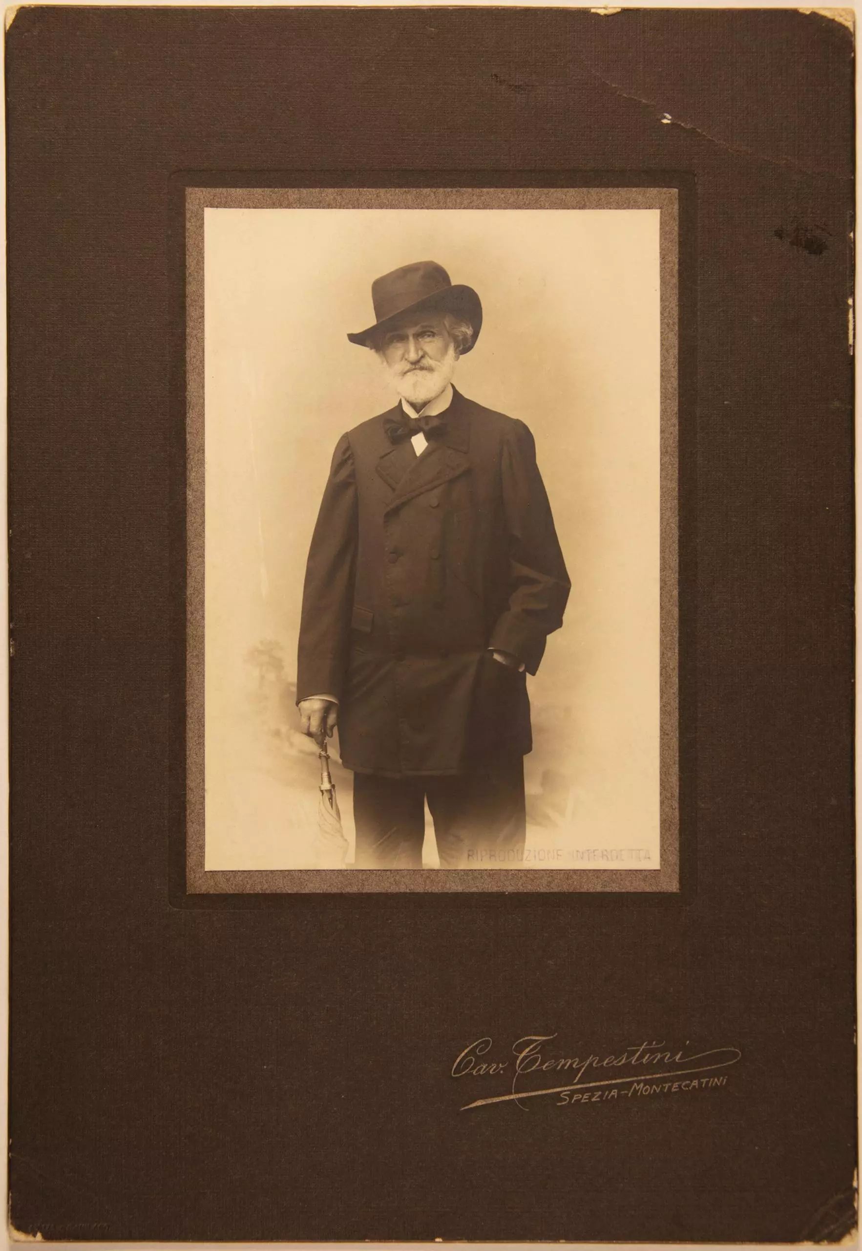 Historisches Porträt eines Mannes mit Hut und Anzug in Passepartout-Rahmung mit Signatur.