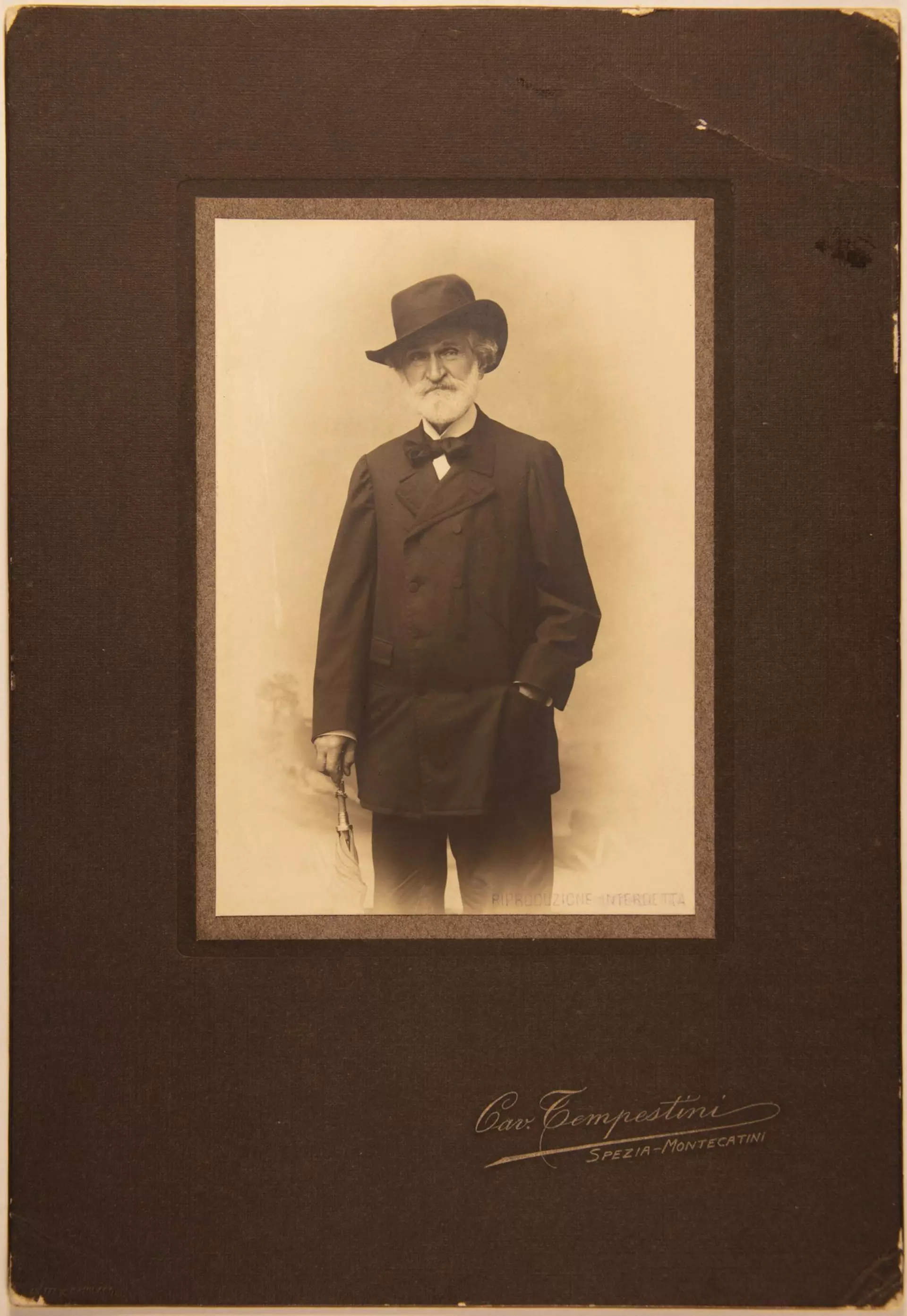 Historisches Porträt eines Mannes mit Hut und Anzug in Passepartout-Rahmung mit Signatur.