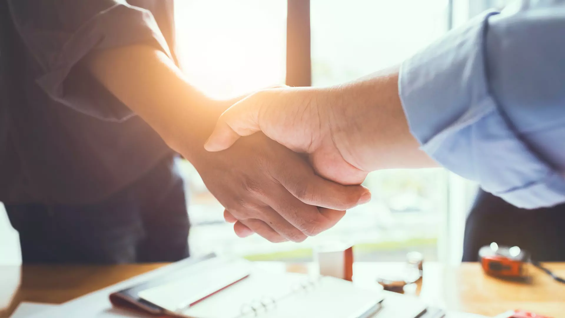 Handshake between two men at a desk