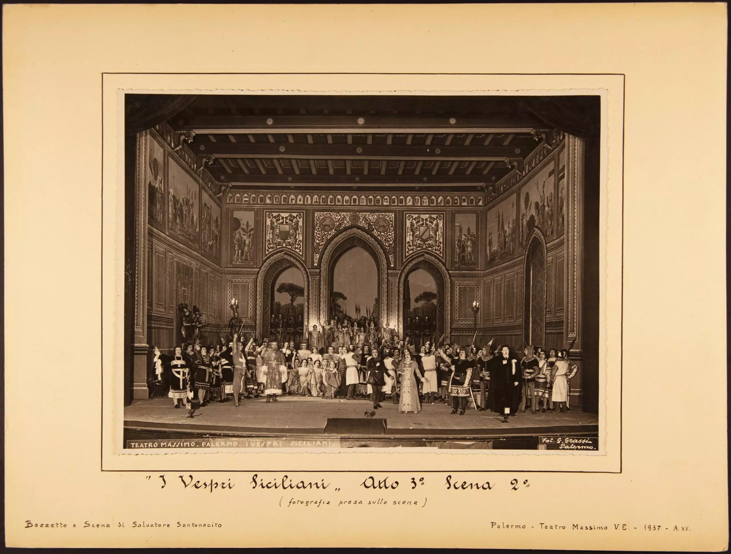 Historische Bühnenaufnahme mit großem Ensemble vor orientalisch anmutender Kulisse mit Bögen und Dekor.