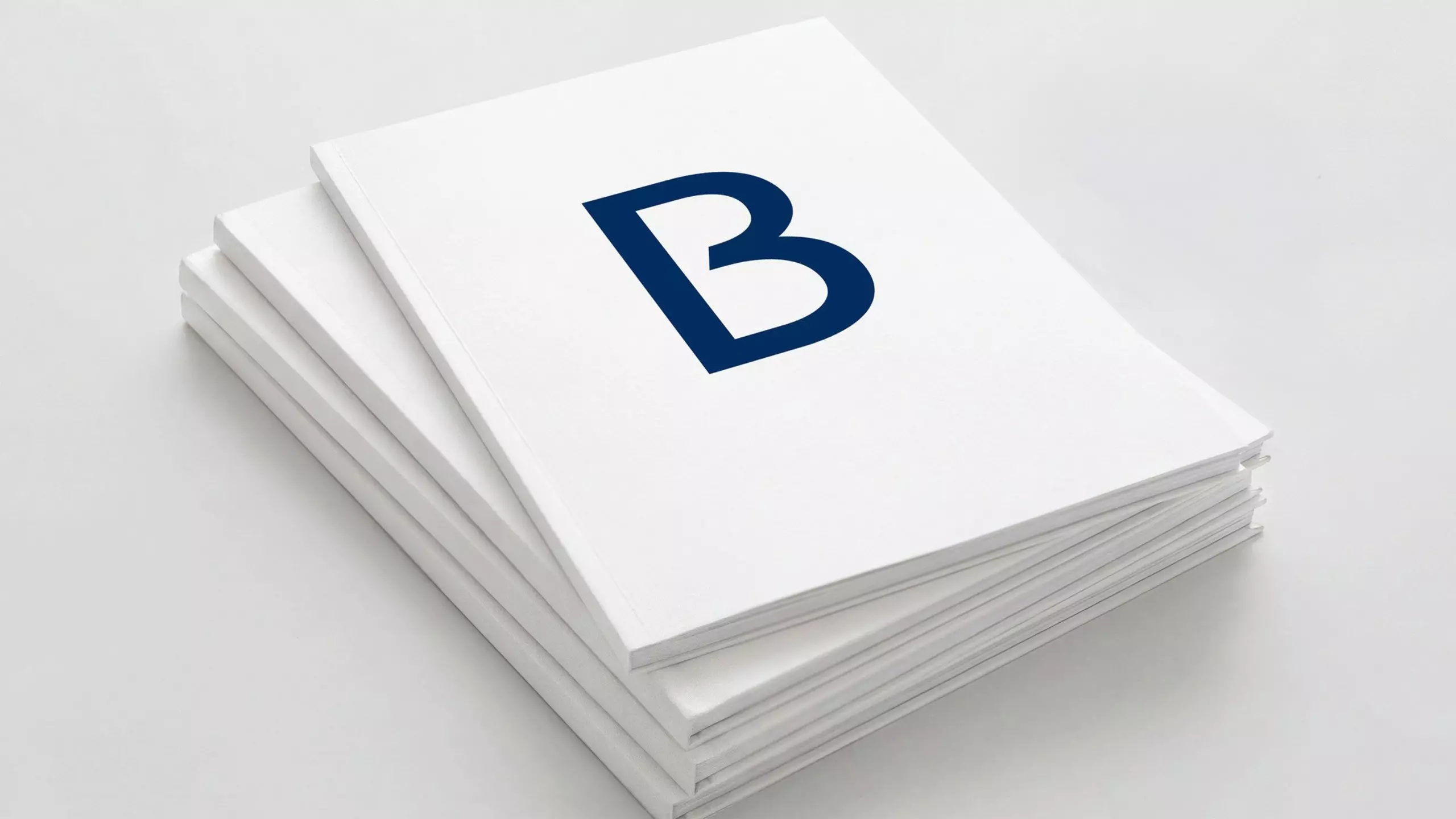 Stack of white reports or books with a large blue letter B on the top cover.