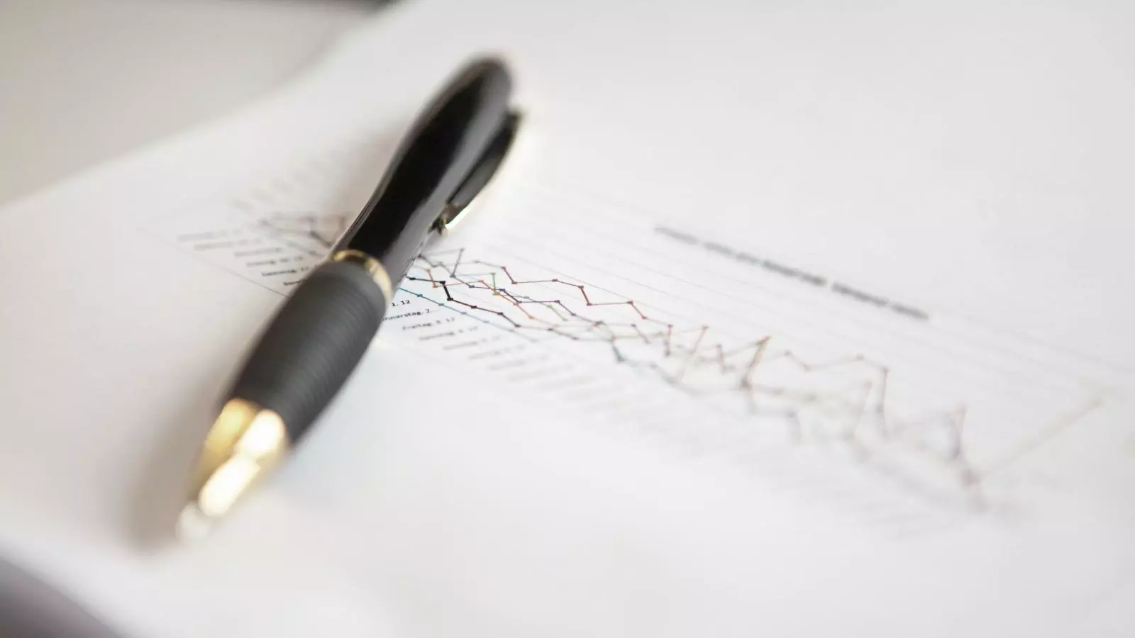 Pen resting on a printed line chart.